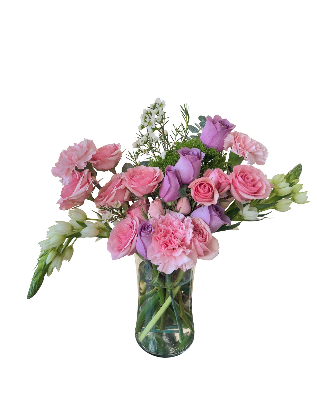 This floral arrangement from L’amour Floral Designs is a cheerful mix of soft pink and lavender roses, light pink carnations, delicate white blooms, and lush greenery displayed in a clear glass vase. The colors are balanced beautifully, evoking a romantic and uplifting tone perfect for springtime occasions or heartfelt sentiments. The arrangement is fresh, airy, and feminine, ideal for expressing love, appreciation, or warm wishes.