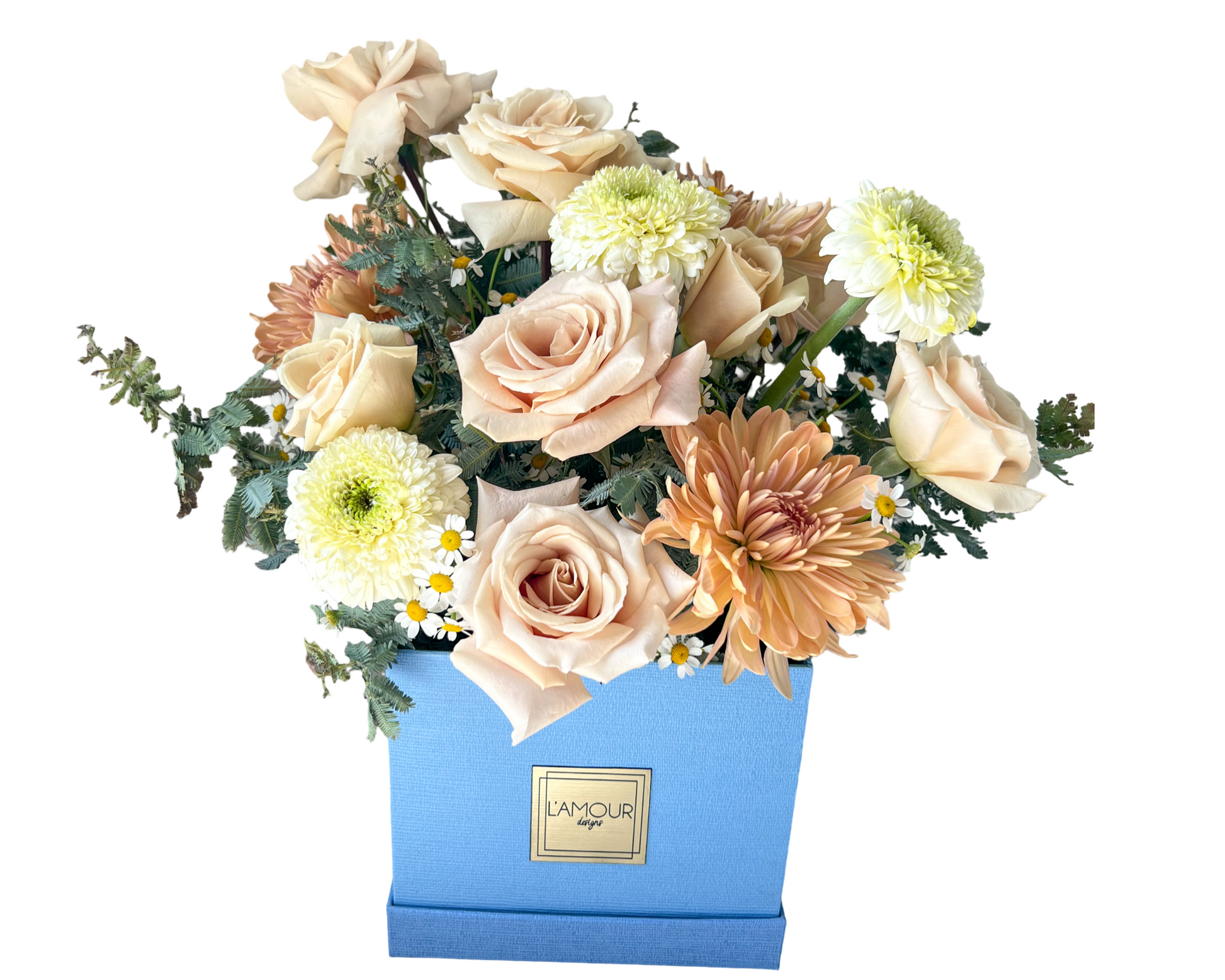 A delicate floral arrangement in a powder blue L’amour Designs gift box featuring soft peach roses, beige roses, cream chrysanthemums, light green-centered pompom mums, and small white chamomile daisies. Accented with soft greens and textured foliage, this bouquet is ideal for thank-you gifts, spring decor, or subtle celebrations.