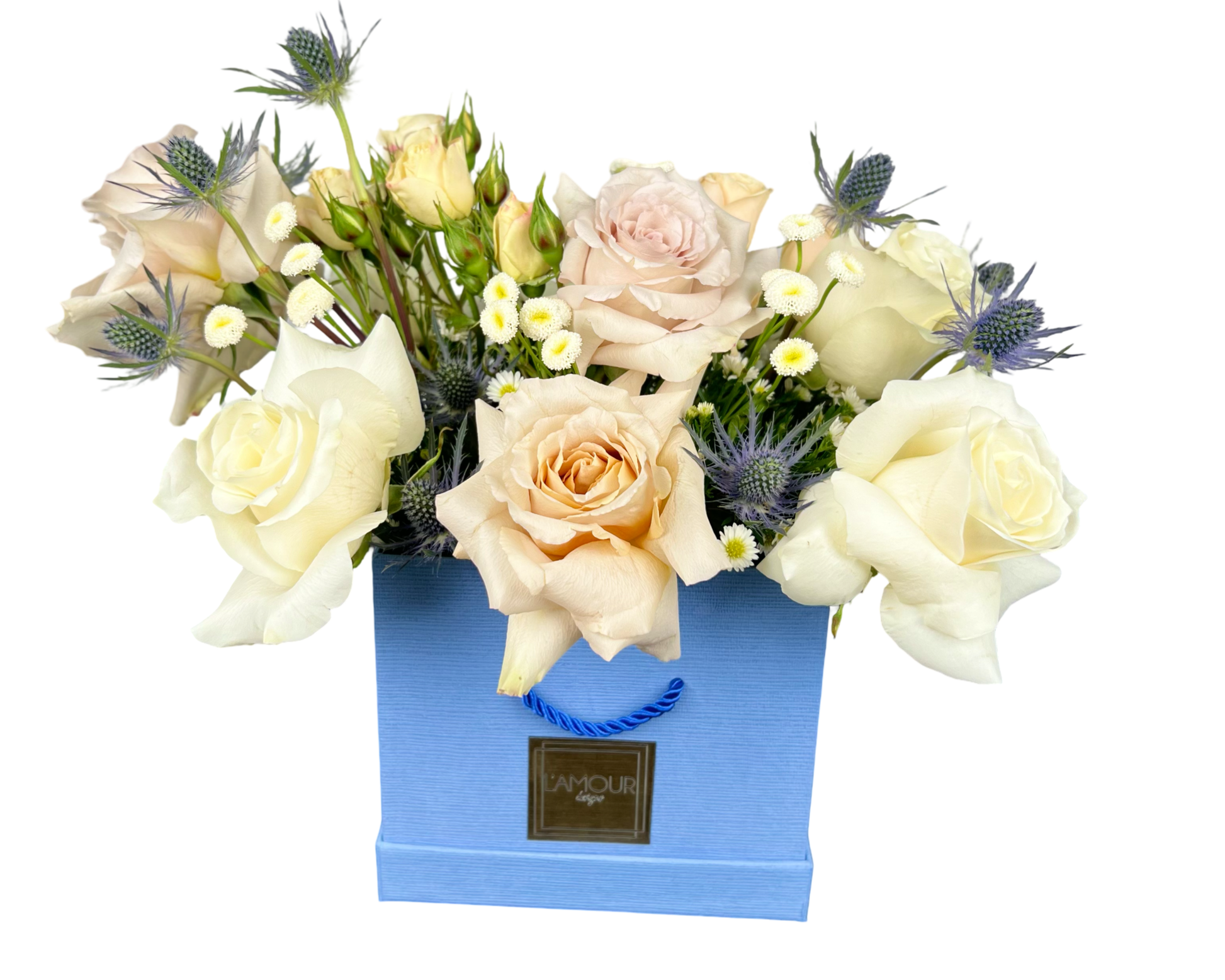 A stylish floral arrangement displayed in a powder-blue square gift bag from L’amour Designs. This elegant bouquet features cream and champagne roses, light peach spray roses, chamomile daisies, and blue eryngium thistle, blending soft neutrals with subtle pops of blue for a contemporary and gender-neutral gift. Ideal for elegant celebrations, corporate gifting, or welcoming a new baby boy.