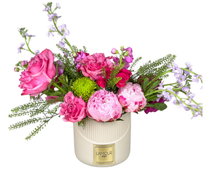 A romantic garden-inspired arrangement in a ribbed cream ceramic vase from L’amour Designs, featuring pink roses, peonies, spray roses, bright green button chrysanthemums, lavender stock, and assorted greens. The vibrant mix of textures and tones makes it perfect for celebratory moments, spring gifting, or romantic gestures.